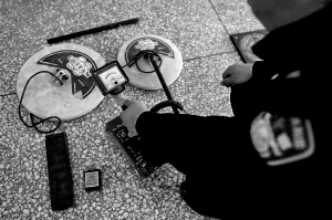 民警展示盗墓者使用的金属探测仪。资料图片